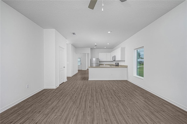 8415 98th Ct, Vero Beach, FL 32967 - unfurnished living room with dark wood-type flooring, ceiling fan, a textured ceiling, and recessed lighting
