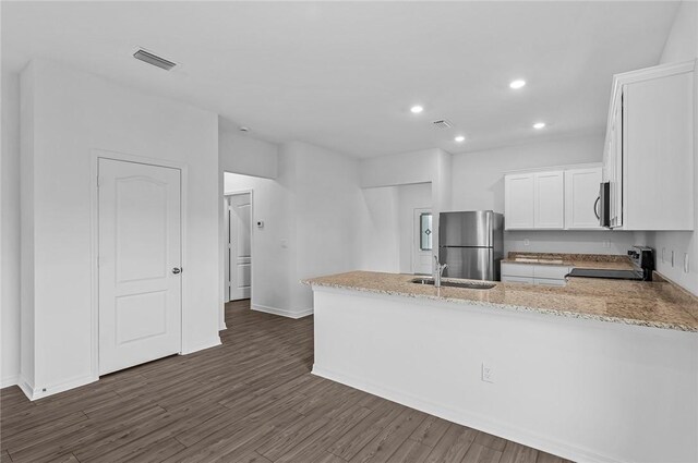 8415 98th Ct, Vero Beach, FL 32967 - kitchen featuring appliances with stainless steel finishes, white cabinetry, a peninsula, recessed lighting, and light stone countertops