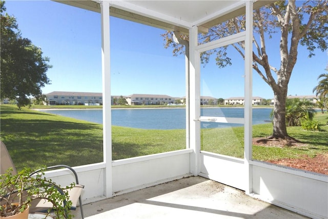 sunroom featuring a water view