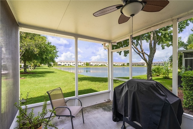 sunroom / solarium featuring a water view and ceiling fan