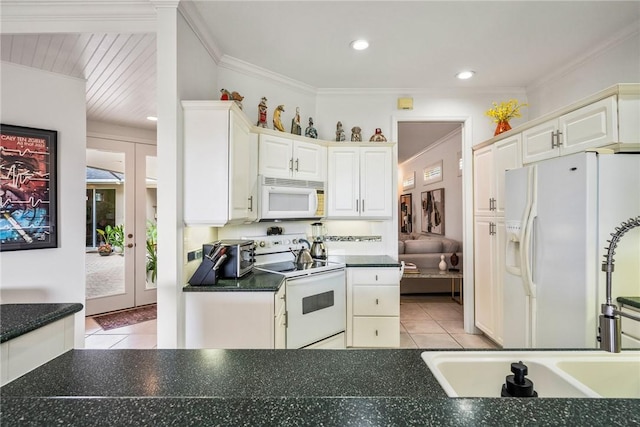 kitchen with white cabinets, light tile patterned floors, and white appliances