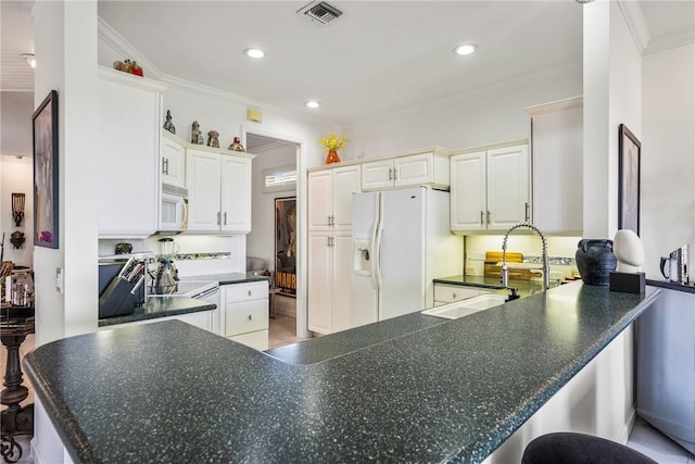 kitchen with kitchen peninsula, ornamental molding, white appliances, white cabinets, and a breakfast bar area