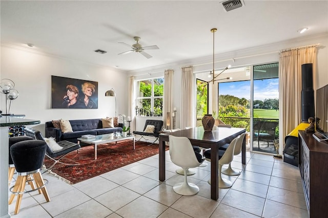 tiled dining space featuring ceiling fan and crown molding