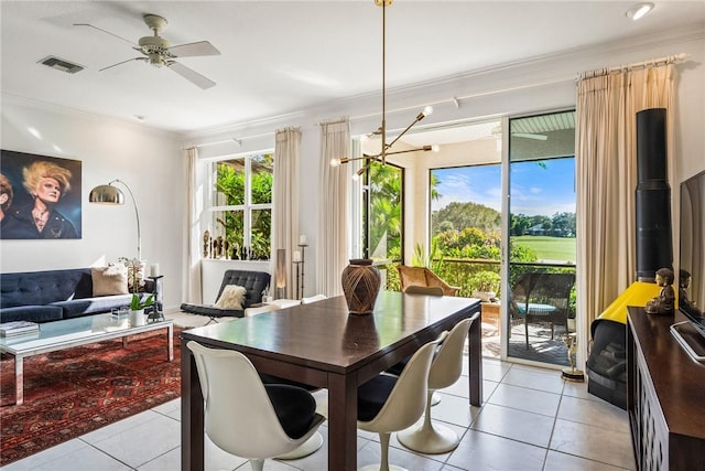 dining space with crown molding, light tile patterned flooring, and ceiling fan with notable chandelier