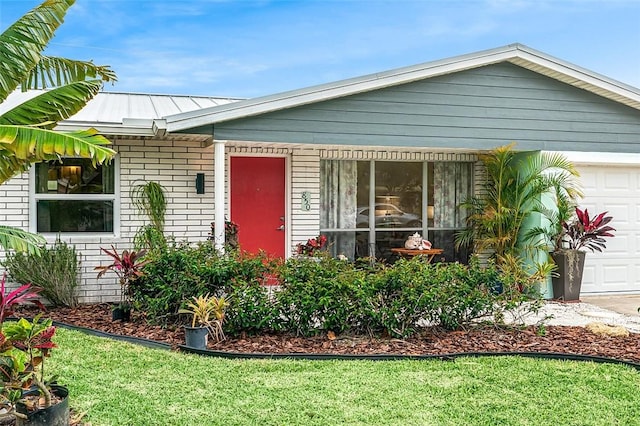 850 Gilbert St, Sebastian, FL 32958 - view of front facade with a garage, brick siding, and a front lawn