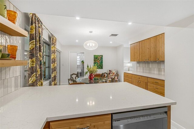 850 Gilbert St, Sebastian, FL 32958 - kitchen with open shelves, dishwashing machine, brown cabinetry, tasteful backsplash, and light stone countertops