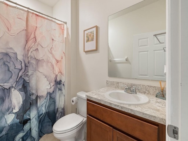 bathroom with curtained shower, toilet, and vanity