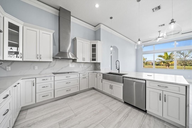 kitchen featuring pendant lighting, white cabinetry, sink, stainless steel dishwasher, and wall chimney exhaust hood