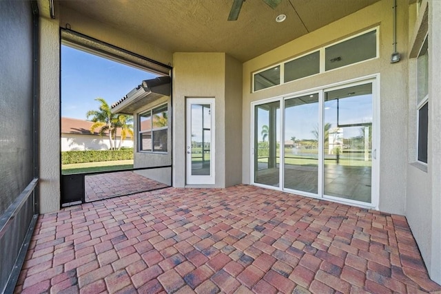 unfurnished sunroom with ceiling fan