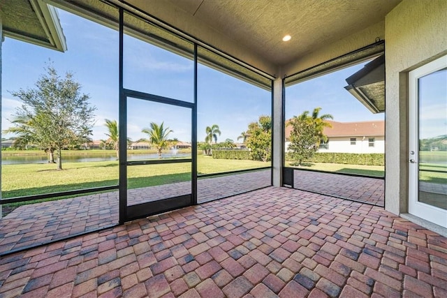 unfurnished sunroom with a water view