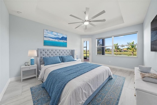 bedroom featuring a raised ceiling and ceiling fan