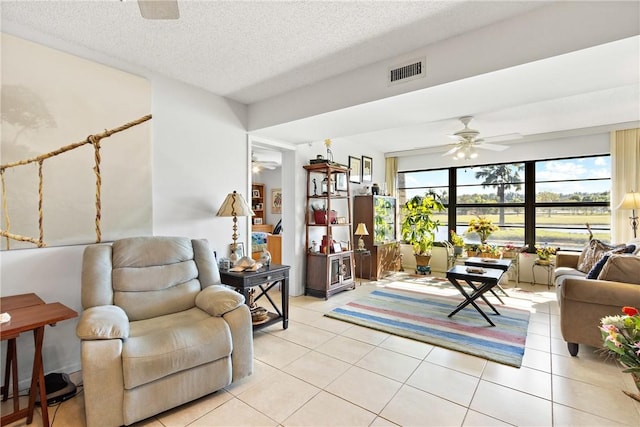 tiled living room with a textured ceiling and ceiling fan