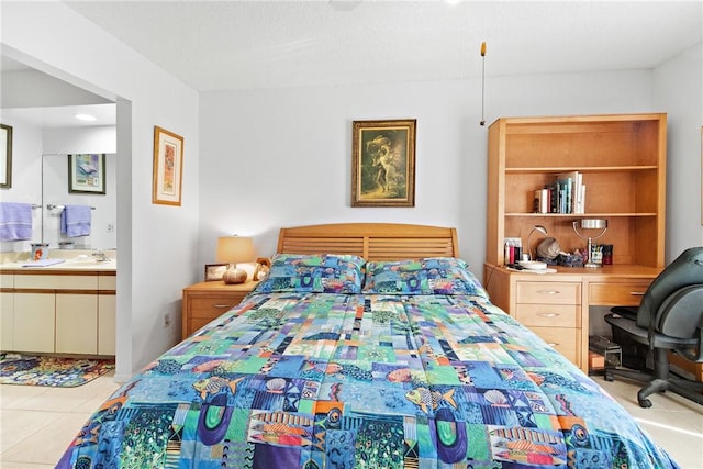 bedroom featuring connected bathroom, light tile patterned floors, built in desk, and sink