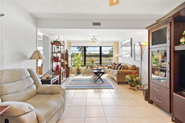 tiled living room with ceiling fan and a textured ceiling