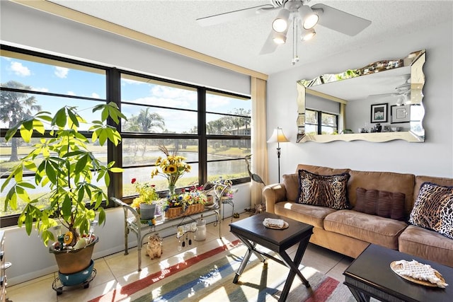 living room featuring light tile patterned floors, a textured ceiling, and ceiling fan