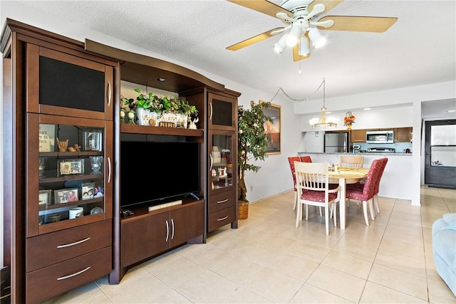 dining area with light tile patterned floors, a textured ceiling, and ceiling fan