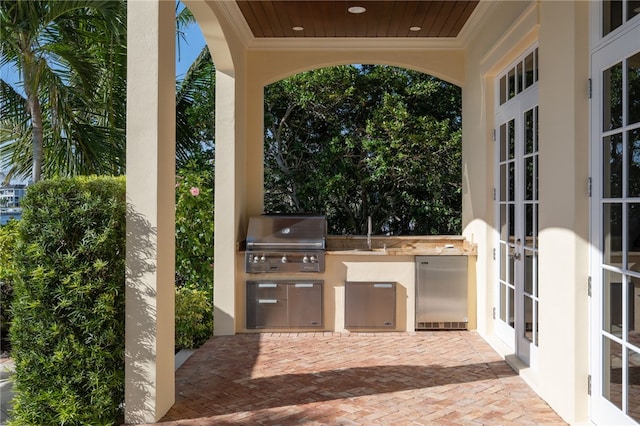 view of patio with area for grilling, an outdoor kitchen, and french doors