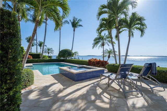 view of pool featuring a patio, a pool with connected hot tub, and a water view