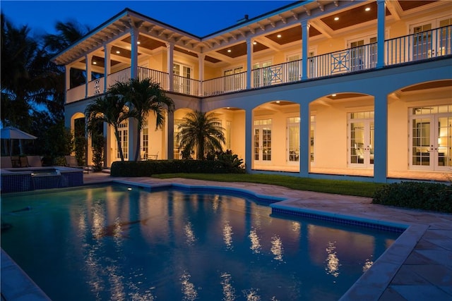 view of pool featuring a patio area, french doors, and a pool with connected hot tub