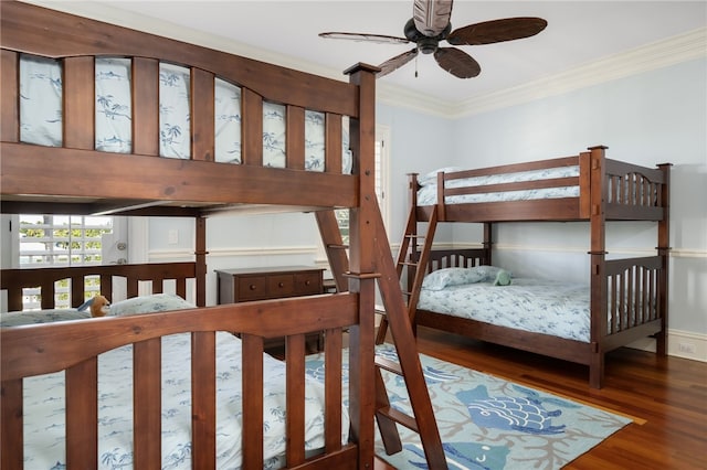 bedroom featuring baseboards, wood finished floors, and ornamental molding