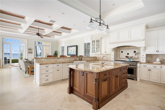 kitchen with backsplash, light stone counters, custom exhaust hood, coffered ceiling, and high end stainless steel range