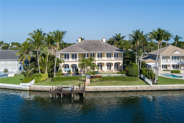 back of house featuring a water view and a balcony