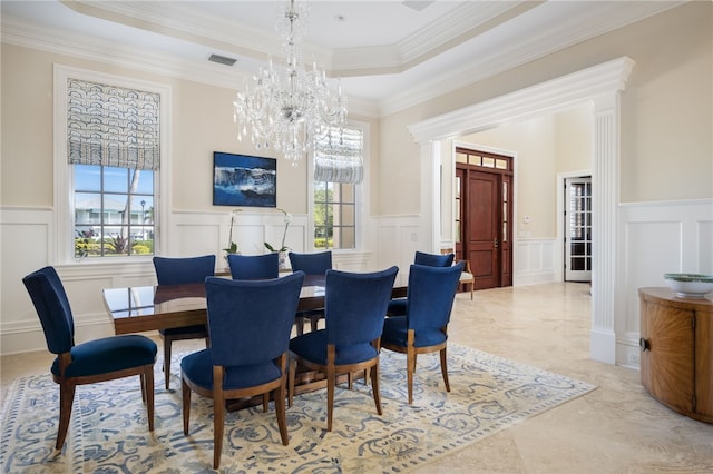 dining space with an inviting chandelier, a raised ceiling, a wainscoted wall, and visible vents