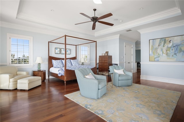 bedroom featuring visible vents, ornamental molding, a raised ceiling, and wood finished floors