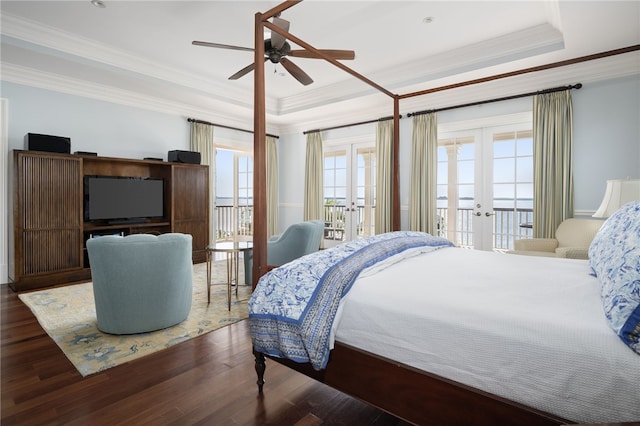 bedroom featuring wood finished floors, french doors, crown molding, a raised ceiling, and access to exterior