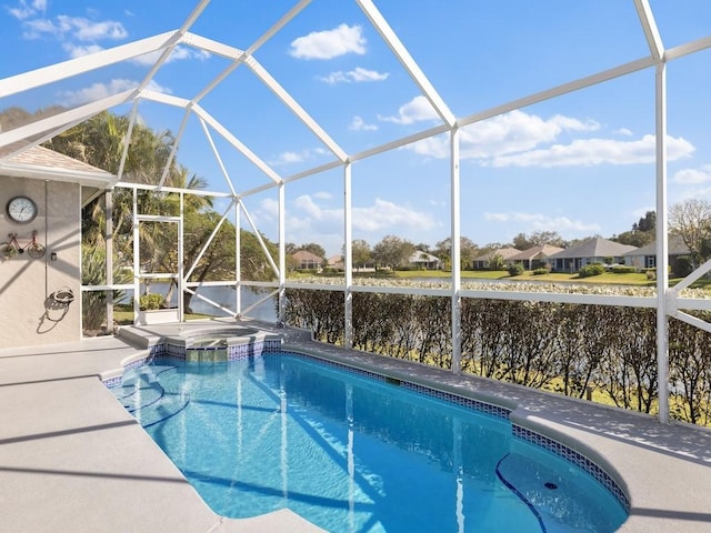 view of swimming pool with glass enclosure and a water view