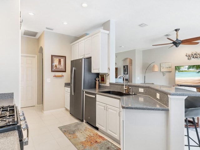 kitchen featuring white cabinets, a kitchen breakfast bar, sink, and appliances with stainless steel finishes