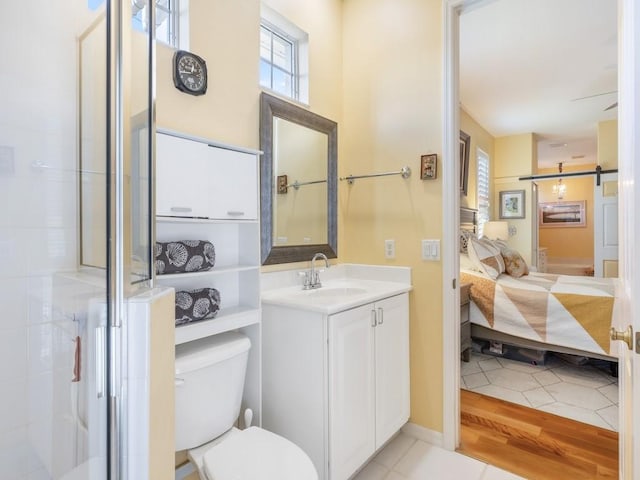 bathroom featuring tile patterned flooring, vanity, toilet, and a shower with shower door