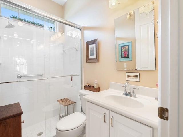 bathroom with vanity, toilet, and a shower with door