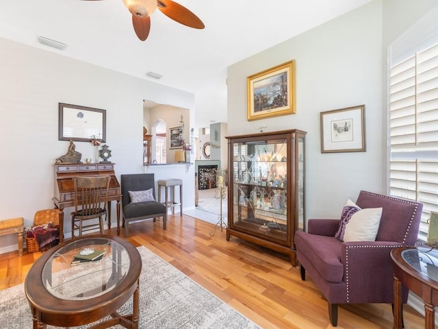 living area featuring hardwood / wood-style floors and ceiling fan