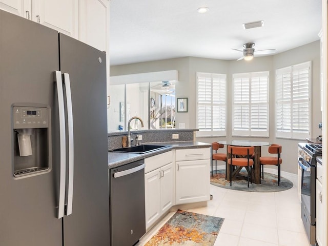 kitchen with sink, ceiling fan, light tile patterned floors, white cabinetry, and stainless steel appliances