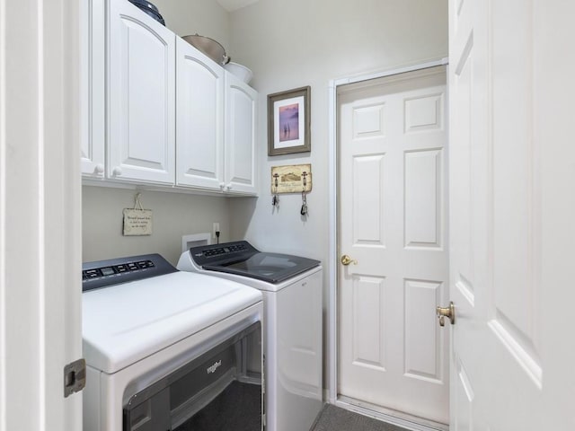 laundry area featuring washing machine and clothes dryer and cabinets