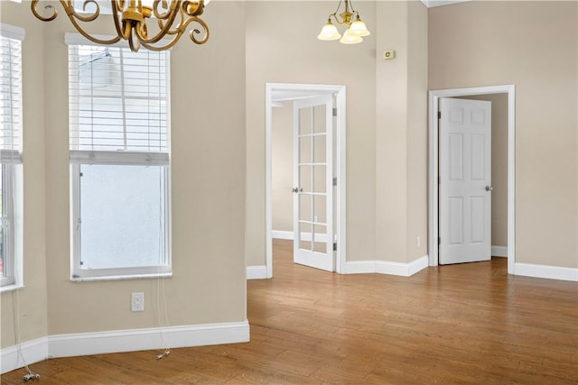 unfurnished room featuring hardwood / wood-style floors and a notable chandelier