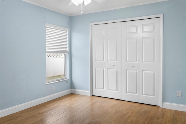 unfurnished bedroom featuring light wood-type flooring, a closet, and ceiling fan