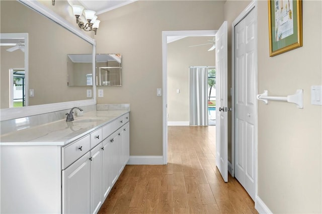 bathroom with hardwood / wood-style floors, vanity, and a chandelier