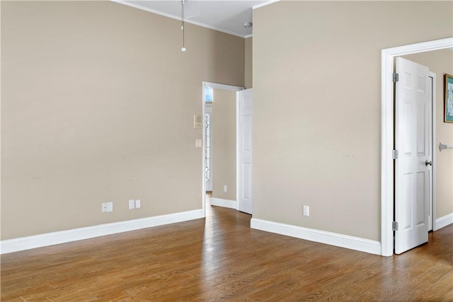 empty room with wood-type flooring and crown molding