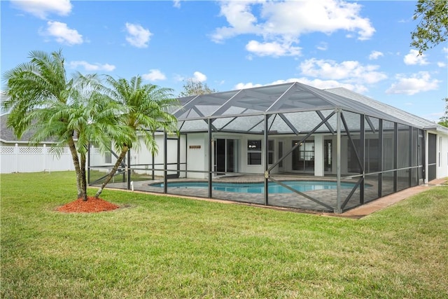 view of swimming pool featuring glass enclosure and a yard