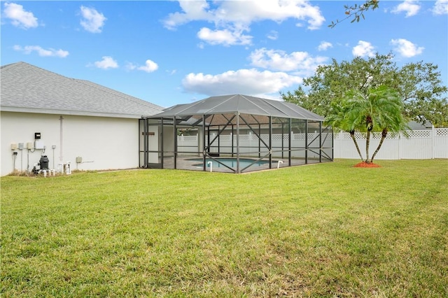 view of yard featuring glass enclosure and a fenced in pool