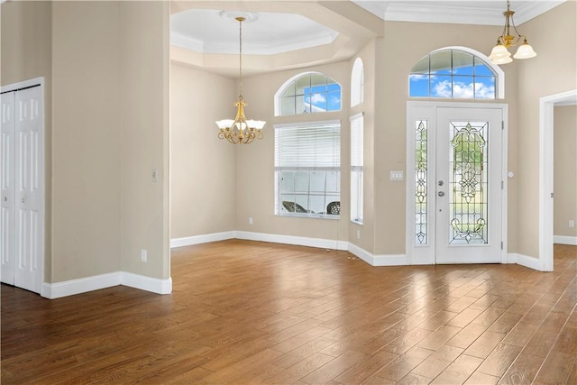 foyer entrance featuring a chandelier, hardwood / wood-style flooring, and crown molding