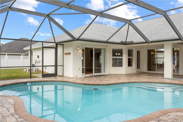 view of pool with glass enclosure and a patio