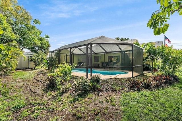 pool with a lanai, a storage unit, a patio, and an outbuilding