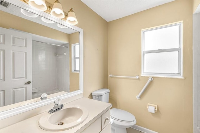 bathroom with baseboards, visible vents, toilet, walk in shower, and vanity