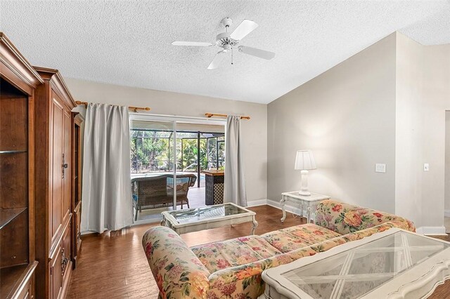 living room with baseboards, a textured ceiling, a ceiling fan, and wood finished floors