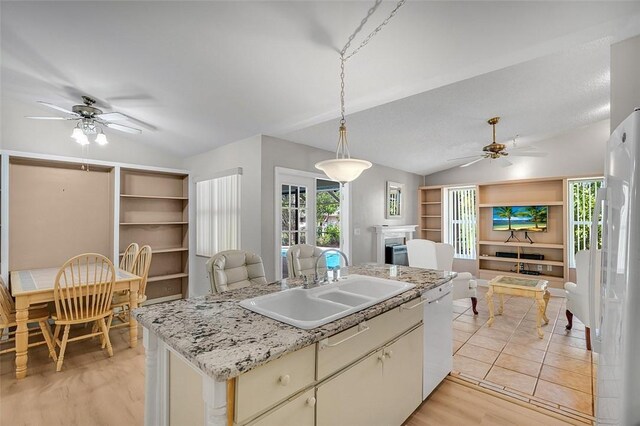 kitchen with vaulted ceiling, white appliances, a sink, and open floor plan