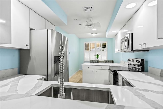 5520 N Harbor Village Dr Unit 204, Vero Beach, FL 32967 - kitchen featuring appliances with stainless steel finishes, a ceiling fan, light stone counters, and white cabinetry