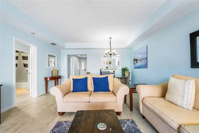 5520 N Harbor Village Dr Unit 204, Vero Beach, FL 32967 - living room with a chandelier, wood finished floors, baseboards, and a raised ceiling